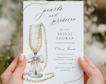 May include: A bridal shower invitation with the words "pearls and prosecco" in elegant script. The invitation features a champagne glass with a pearl necklace and bow. The text invites guests to celebrate the bride-to-be, Olivia Thomas.