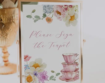 May include: A white sign with pink floral accents and a stack of pink teacups. The sign says "Please Sign the Teapot".
