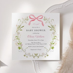 Peut inclure: Une invitation de fête prénatale rose et blanche avec une couronne de fleurs et un nœud rose. Le texte indique "C'est une fille ! Rejoignez-nous pour une fête prénatale célébrant Olivia Wilson. Samedi 23 juin à 14 h 00. The Event Place 123 Willow Lane | City, State 12345. RSVP à Katie 814-324-5678. Enregistré chez Target."