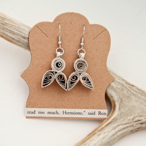 May include: A pair of dangle earrings made from coiled paper strips in shades of cream, brown, and black, attached to silver-toned metal hooks. The earrings are displayed on a tan card with the printed text, read too much, Hermione, said Ron.