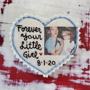 May include: A heart-shaped embroidered patch with a photo of two people and the text "Forever your little girl" with a red heart and the date "8-1-20".