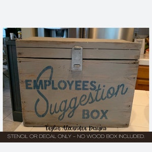 May include: A wooden box with a blue stencil that says "Employees Suggestion Box" and the text "Taylor Alexandria Designs" at the bottom.