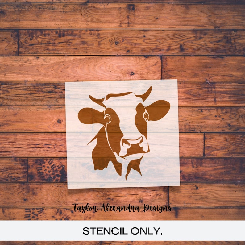 May include: A brown and white cow stencil for crafting projects. The stencil is on a white background and has the text "Taylor Alexandra Designs" and "STENCIL ONLY." at the bottom.