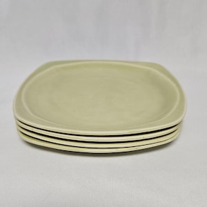 Può includere: Quattro piatti da cena in ceramica verde chiaro impilati con bordi arrotondati.