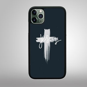 May include: A black phone case with a white cross and the word "Jesus" written in white cursive. The phone case has a camera lens cutout.