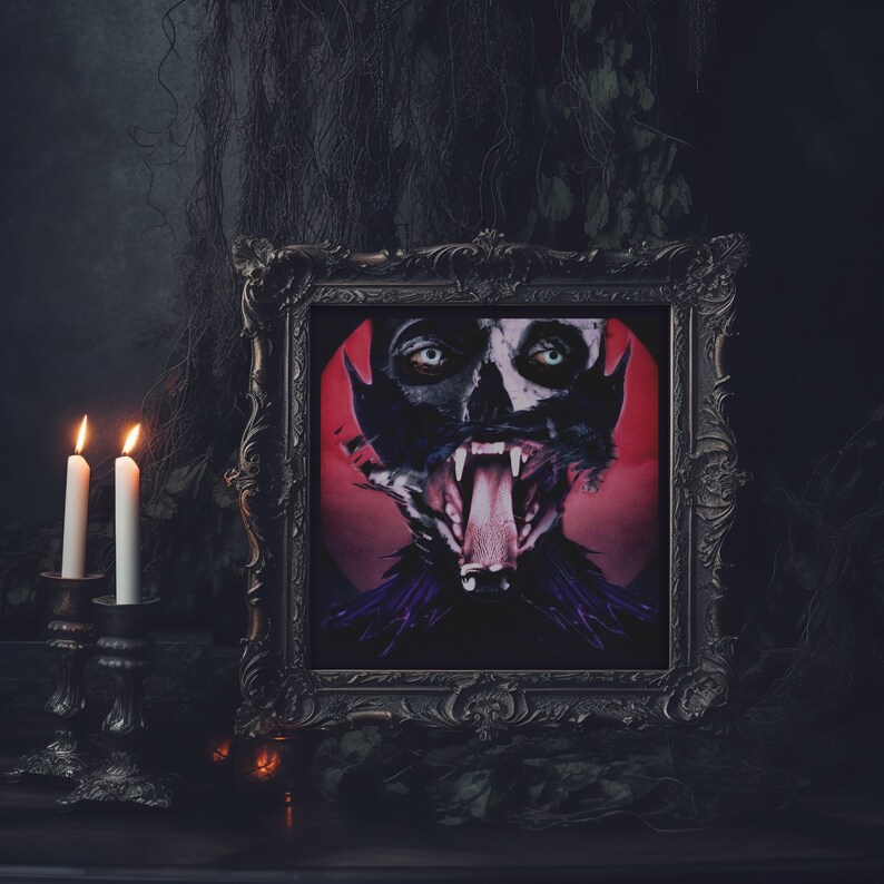 May include: A black ornate picture frame with a red and black image of a person with a wolf-like face and a large open mouth. The person is wearing a black and purple costume. Two lit candles are in the foreground.
