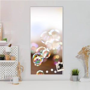 Op de afbeelding: Een wit magnetisch bord met een foto van een hond en een kleurrijk bellenbeeld. Het bord heeft drie witte magnetische stippen.