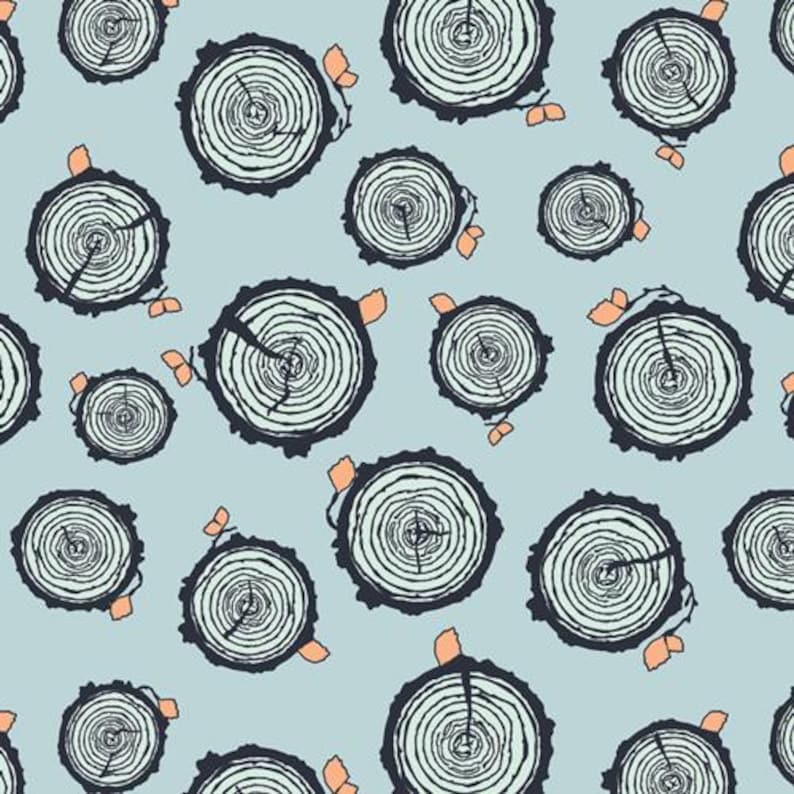 May include: A seamless pattern featuring a repeating design of tree rings in shades of blue and green on a light blue background. The tree rings are stylized and have a rustic, natural feel.