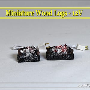May include: Two miniature wood log sets with glowing embers, each with a white cord and plug. Miniature Wood Logs - 12V is written in yellow text on a gold banner.