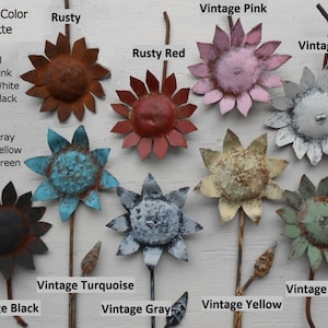 May include: A collection of ten metal sunflower-shaped ornaments in various vintage colors, including rusty, rusty red, vintage pink, vintage white, vintage black, vintage turquoise, vintage gray, vintage yellow, and vintage green.