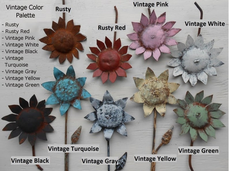 May include: A collection of ten metal sunflower-shaped ornaments in various vintage colors, including rusty, rusty red, vintage pink, vintage white, vintage black, vintage turquoise, vintage gray, vintage yellow, and vintage green.