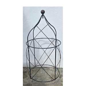 May include: A black metal garden obelisk with a domed top and a spherical finial. The obelisk features a cage-like design with intersecting lines and circular supports, suitable for climbing plants. The structure stands approximately 60 inches tall.