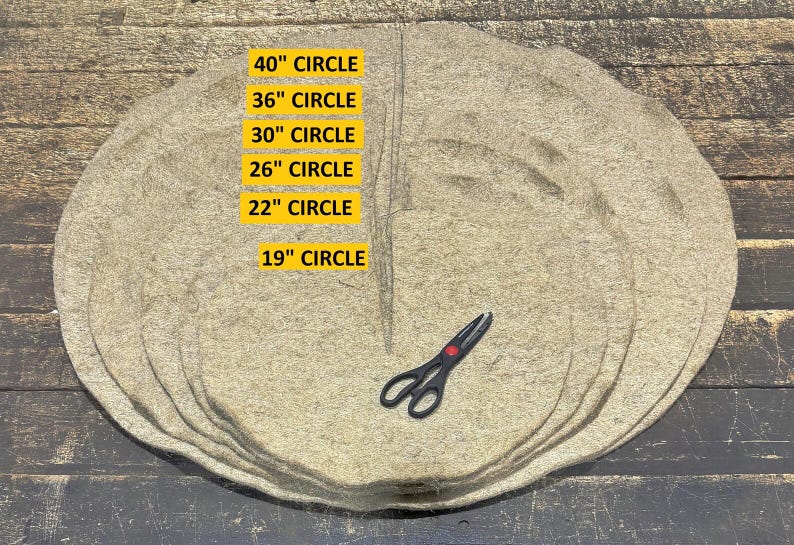 May include: A stack of six circular tan fiber mats with a pair of black scissors placed on top. The mats are labeled with sizes: 40" CIRCLE, 36" CIRCLE, 30" CIRCLE, 26" CIRCLE, 22" CIRCLE, and 19" CIRCLE, indicating their respective diameters in inches.