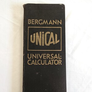 May include: A vintage black calculator with gold lettering. The text on the cover reads "BERGMANN UNICAL UNIVERSAL CALCULATOR". The calculator is rectangular and appears to be made of a durable material.