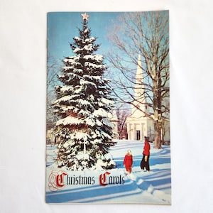 May include: Vintage Christmas card featuring a snow-covered evergreen tree topped with a star. The card shows a church and two people in the snow. The words "Christmas Carols" are printed in red script.