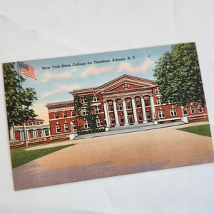 May include: A vintage postcard depicting the New York State College for Teachers in Albany, New York. The postcard shows a red brick building with a white columned entrance and a large American flag flying in the breeze.
