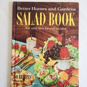 May include: A vintage cookbook titled "Better Homes and Gardens SALAD BOOK" with a brown cover and yellow lettering. The cover features a colorful spread of salads and fruits. The book promises "New salad ideas for every occasion" and "More than 350 RECIPES".