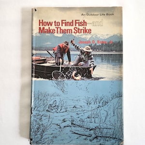 May include: Vintage book cover titled "How to Find Fish - and Make Them Strike." The cover features a fishing scene with two people in a boat, and the underwater scene with aquatic plants. The book is an Outdoor Life Book.
