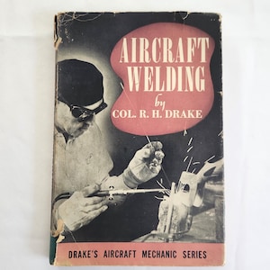 May include: Vintage book titled "Aircraft Welding" by Col. R. H. Drake. The cover features a black and red design with an illustration of a welder at work. The book is part of Drake's Aircraft Mechanic Series.