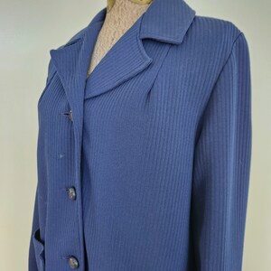 May include: A navy blue ribbed long-sleeved jacket with a button-up front and two pockets.