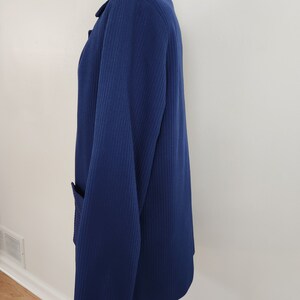 May include: A navy blue blazer with a ribbed texture and a single pocket on the left side.