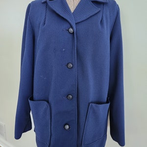 May include: A navy blue blazer with a ribbed texture and four black buttons. The blazer has two patch pockets on the front.