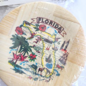 Puede incluir: Un juego de posavasos de bamb&uacute;. El posavasos redondo presenta un mapa de Florida con nombres de ciudades e ilustraciones. El posavasos tiene un patr&oacute;n de vetas de madera clara y est&aacute; decorado con im&aacute;genes coloridas.