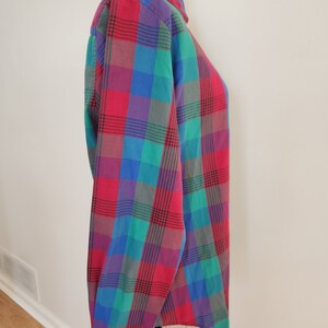 May include: A long-sleeved button-down shirt with a plaid pattern in shades of red, green, blue, and purple.