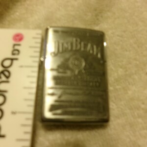 May include: A white ceramic mug with a black handle and the text "But First, Coffee" in a black, bold font. The mug is on a white surface.