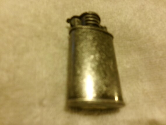 flip top cigarette lighter Metal and the arm returns that force to strike the flint Flip-Top Lighters