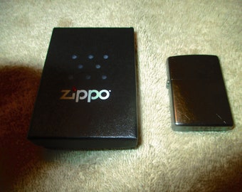 Encendedor Zippo vintage cromado, aún en su caja negra original. Nunca usado.