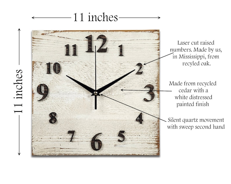 May include: A white distressed wood square clock with black hands and black raised numbers. The clock is 11 inches wide and 11 inches tall. The clock is made from recycled cedar and has a silent quartz movement with a sweep second hand.