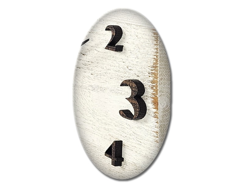 May include: Close-up of a white wooden clock face with black numbers 2, 3, and 4.