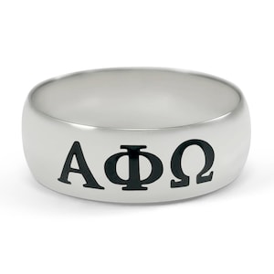 Könnte beinhalten: Ein silberner Ring mit den Buchstaben AΦΩ in Schwarz graviert.