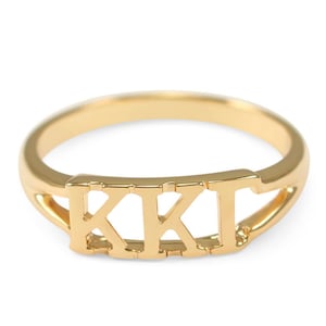 May include: A gold ring with the letters "KKT" engraved on it.