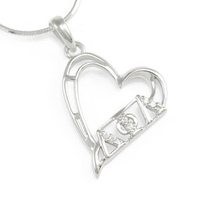 May include: Silver heart-shaped pendant necklace with the Greek letters 'ΑΦΑ' set with small clear stones.