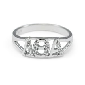 May include: A silver ring with the letters "AVA" set with small diamonds.