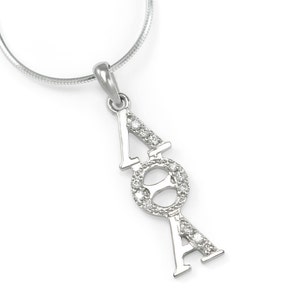 May include: A silver pendant necklace with a diamond-encrusted Greek letter design. The letters are arranged vertically, with the top letter being a 'A', followed by a circle with a 'O' inside, and then another 'A' at the bottom.