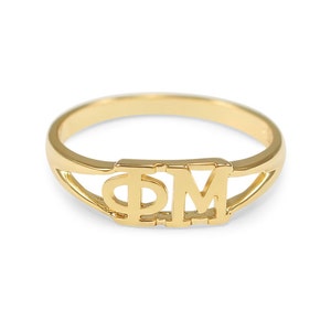 May include: A gold ring with the letters "ΦΜ" engraved on it.