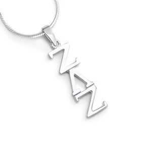 Può includere: Una collana con pendente in argento con le lettere ZAZ disposte verticalmente. Il pendente è attaccato a una sottile catena d'argento. Lo sfondo è bianco, evidenziando il gioiello.
