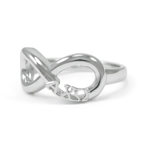 May include: Silver infinity ring with the letters AXQ engraved on the band.