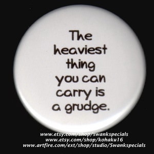 Könnte beinhalten: Runder weißer Knopf mit schwarzem Text, der lautet: "Das schwerste, was du tragen kannst, ist ein Groll."