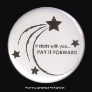 May include: White button with a black and white design. The design features a shooting star with three stars and the text "It starts with you... PAY IT FORWARD".