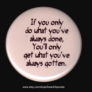 May include: White button with black text that reads "If you only do what you've always done, You'll only get what you've always gotten." The text is handwritten and the button has a website address at the bottom.