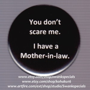 Puede incluir: Botón redondo negro y blanco con el texto "You don't scare me. I have a Mother-in-law." El botón es redondo, plano y negro con texto blanco. El texto está centrado en el botón.