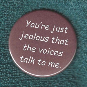 May include: A brown button with white text that reads "You're just jealous that the voices talk to me."