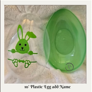 May include: Two plastic Easter egg halves. One is clear with a green bunny graphic, the other is solid green. The text at the bottom reads "10' Plastic Egg add Name".