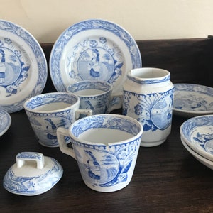 May include: A blue and white porcelain tea set with a floral design. The set includes a teapot, creamer, sugar bowl, cups, and saucers.