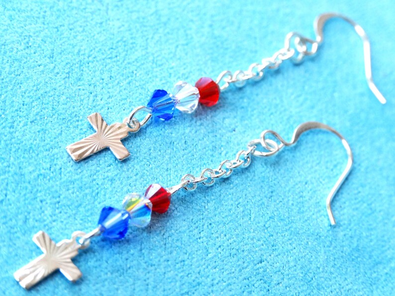 May include: Silver cross earrings with blue and red crystal beads.
