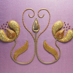 May include: Embroidered floral design with gold and bronze thread on a lavender fabric. The design features two stylized flowers with beaded petals and a central stem with a metallic accent.
